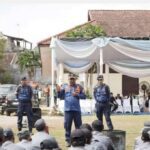 Tak Hanya Jaga Lingkungan, Satlinmas Bandar Lampung Dibekali Keterampilan Hadapi Bencana Pembekalan tersebut diberikan melalui rangkaian pelatihan peningkatan kapasitas yang digelar di Lapangan Kepayang, Gedung Herman HN, Kota Bandar Lampung, Jumat (25/9/2026). Dalam kegiatan itu, anggota Satlinmas mendapat pelatihan pemadam kebakaran dari Dinas Pemadam Kebakaran dan Penyelamatan. Mereka diberikan pengetahuan mengenai langkah awal menghadapi kebakaran, termasuk tindakan keselamatan dan penanganan awal sebelum mendapat penanganan lebih lanjut dari petugas. Selain kebakaran, anggota Satlinmas juga mendapat materi penanggulangan bencana dari Badan Penanggulangan Bencana Daerah (BPBD). Materi yang diberikan mencakup kesiapsiagaan, mitigasi serta langkah-langkah yang perlu dilakukan ketika terjadi bencana atau keadaan darurat di lingkungan masyarakat. Pembekalan ini diarahkan agar anggota Satlinmas memiliki kemampuan dasar untuk merespons kondisi darurat di lingkungan tempat mereka bertugas. Posisi Satlinmas yang berada dekat dengan masyarakat dinilai membuat kemampuan tersebut penting dimiliki. Pelatihan juga mencakup materi kepramukaan yang diberikan untuk mendukung pembentukan karakter, kedisiplinan, kerja sama dan kepemimpinan anggota. Rangkaian kegiatan tersebut menjadi bagian dari upaya meningkatkan kapasitas Satlinmas Bhakti Karya Kota Bandar Lampung agar lebih siap menghadapi berbagai kondisi yang membutuhkan respons cepat. Dengan pembekalan dari unsur pemadam kebakaran, BPBD dan kepramukaan, anggota Satlinmas diharapkan tidak hanya mampu menjalankan tugas perlindungan masyarakat, tetapi juga memiliki kesiapan dasar ketika menghadapi kebakaran maupun bencana di lingkungan sekitar.